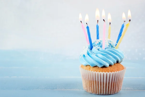 Sabrosos cupcakes azules decorados con velas sobre fondo claro — Foto de Stock