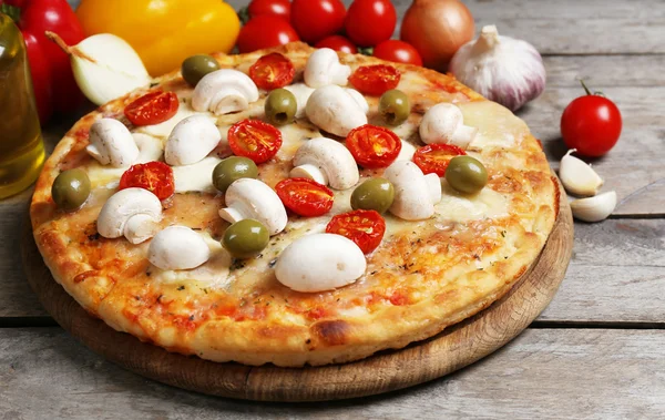 Deliziosa pizza e verdure fresche su sfondo di legno, primo piano — Foto Stock