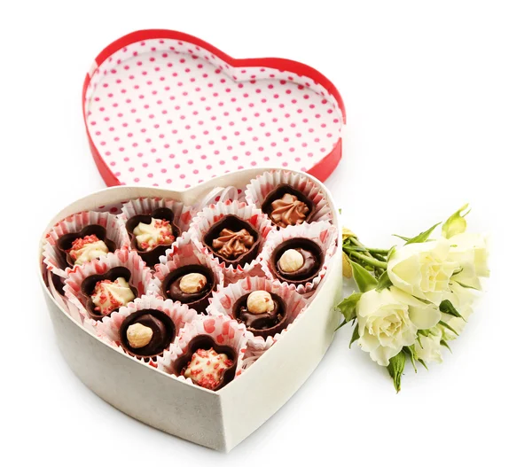 Caja en forma de corazón con caramelos y flores, aislado blanco — Foto de Stock