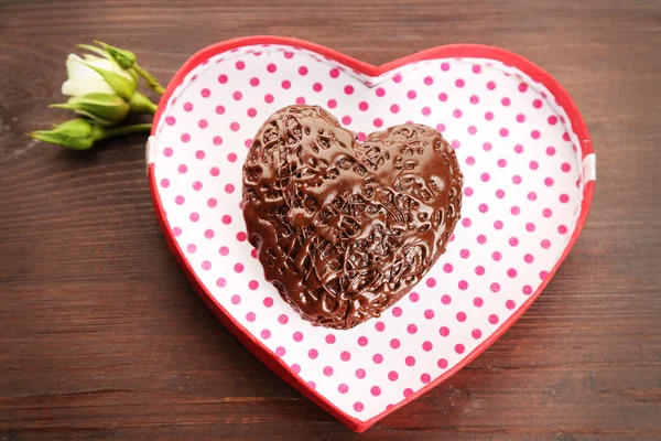 Heart shaped box en snoep op een houten achtergrond, close-up — Stockfoto