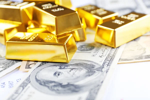 Barras de ouro em notas de dólar — Fotografia de Stock