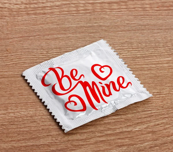 Condom with text n table — Stock Photo, Image