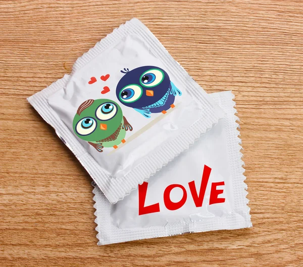 Condoms with pictures on table — Stock Photo, Image