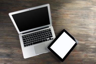 Bir açık gümüş laptop ve modern ahşap arka plan tablete