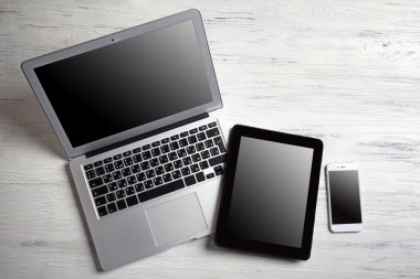 Modern dizüstü bilgisayar, cep telefonu ve Beyaz ahşap zemin üzerinde tablet
