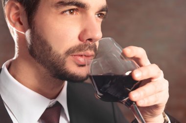 Kırmızı şarap ile takım elbiseli adam