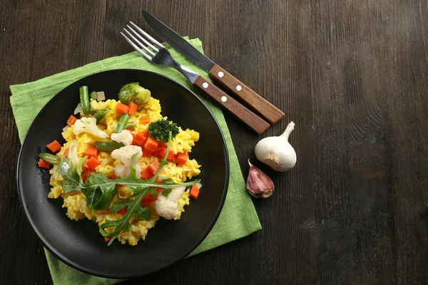 Svart plåt med vegetabiliska risotto på serveras träbord — Stockfoto