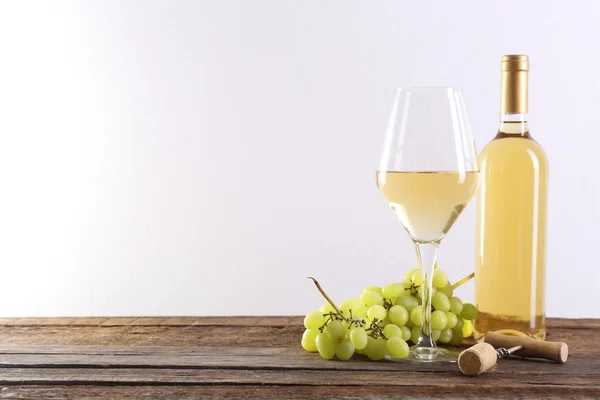 Wijn en druivenmost op houten tafel tegen lichte achtergrond — Stockfoto