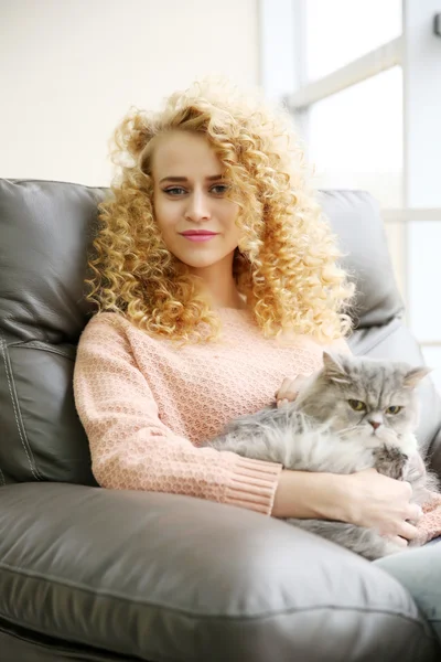 Жінка і кіт на дивані в кімнаті — стокове фото
