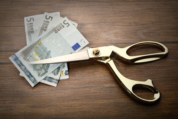 Golden scissors cut money