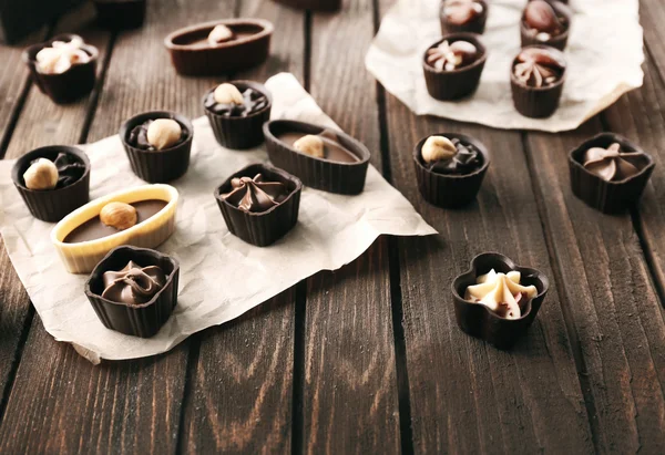 Doces de chocolate em fundo de madeira — Fotografia de Stock