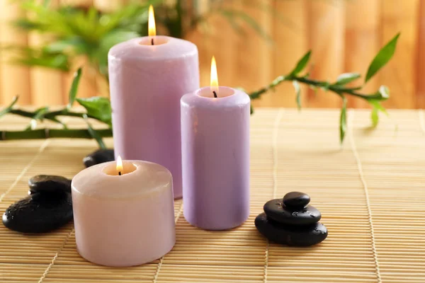 Velas roxas com pedras de spa — Fotografia de Stock