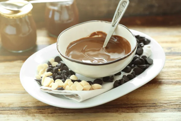 Rozpuszczoną czekoladę w misce, na tle drewniane — Zdjęcie stockowe