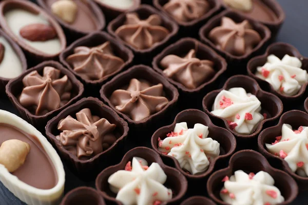 Deliciosos doces de chocolate em fundo de madeira azul, close-up — Fotografia de Stock