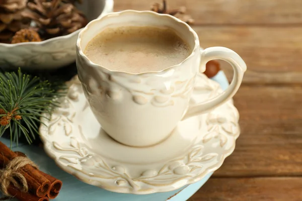 Tasse Kaffee und Christbaumzweig auf Holzmatte — Stockfoto