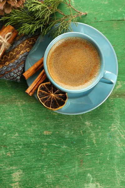 Xícara de café com especiarias doces no guardanapo no fundo de madeira verde — Fotografia de Stock