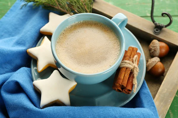 Чашка кофе с печеньем в форме звезды на салфетке на деревянном подносе — стоковое фото