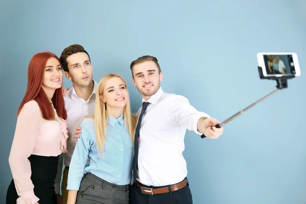 Jongeren Maken Groepsfoto Met Slimme Telefoon Blauwe Muur Achtergrond — Stockfoto