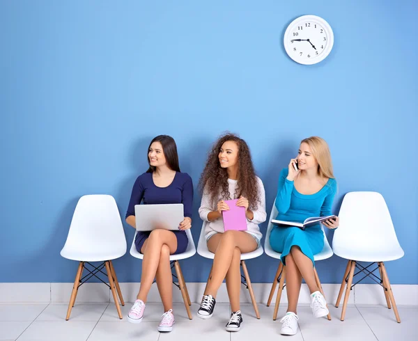 Chicas jóvenes sentadas en sillas — Foto de Stock