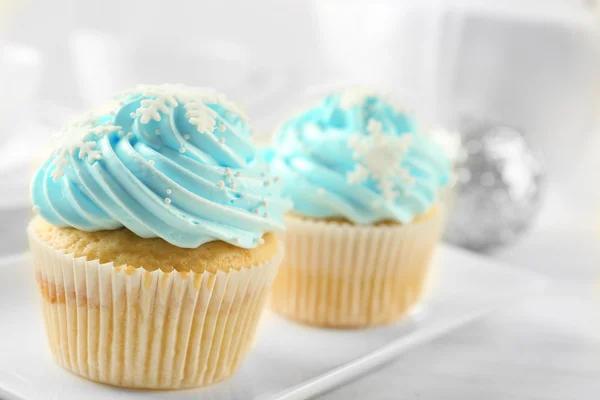 Dois cupcakes azuis saborosos com decorações no fundo leve — Fotografia de Stock