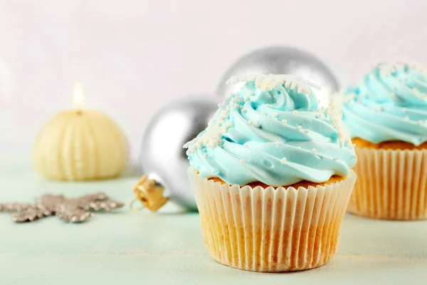 Wenige leckere blaue Cupcakes mit Dekorationen auf hellem Hintergrund — Stockfoto