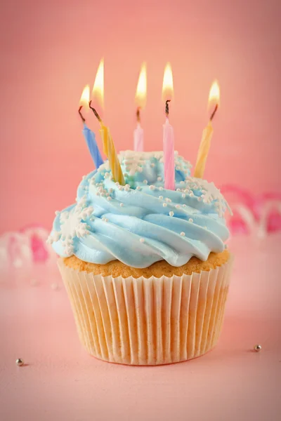 Välsmakande cupcake dekorerad med ljus på rosa bakgrund — Stockfoto