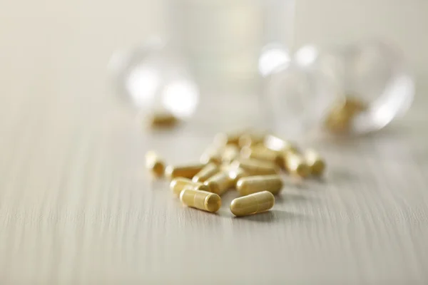 Gele capsules gemorst uit pil fles — Stockfoto