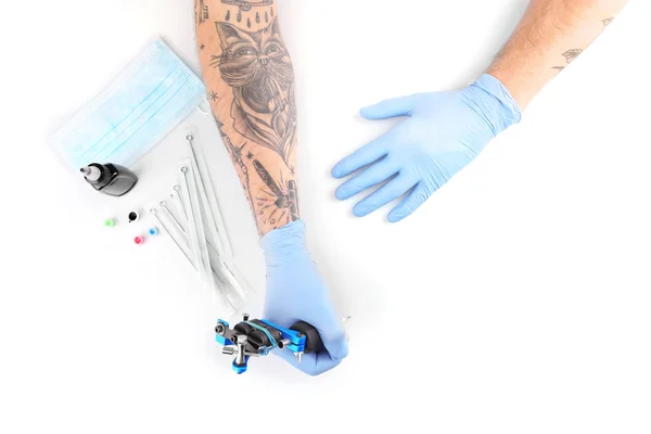 Mãos de tatuador em luvas azuis — Fotografia de Stock