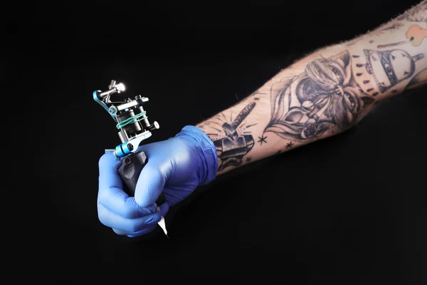 Tattooist ruku s tetování stroj — Stock fotografie