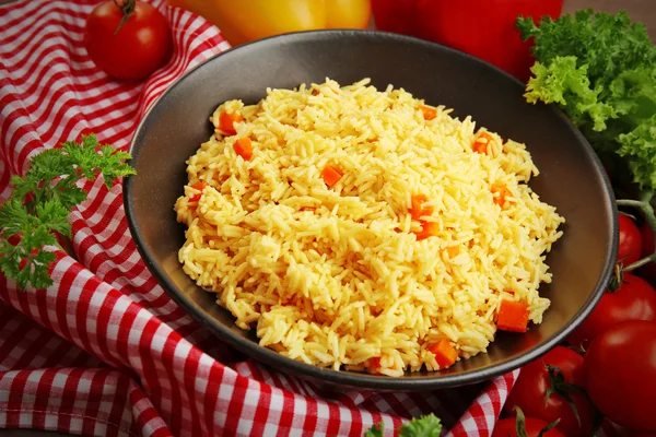 Тушеный рис с морковью на черной тарелке — стоковое фото