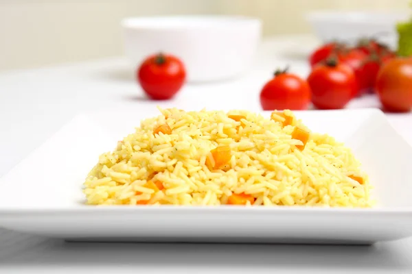 Gestoofde rijst met een wortel op een witte plaat, close-up — Stockfoto