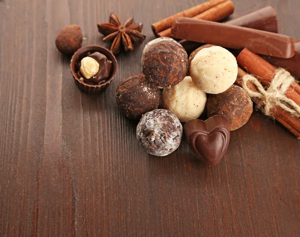 Ahşap arka plan üzerinde çeşitli çikolata şekerleme yakın çekim — Stok fotoğraf
