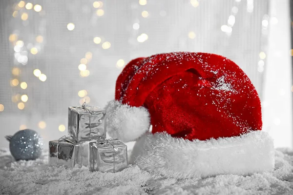 Chapéu Papai Noel com bugigangas e caixas de presente — Fotografia de Stock