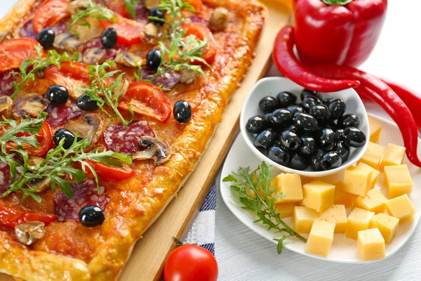 Rectangle delicious pizza and vegetables on the table — Stock Photo, Image