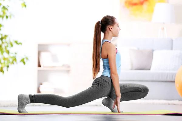 Chica joven haciendo ejercicio de fitness en interiores —  Fotos de Stock