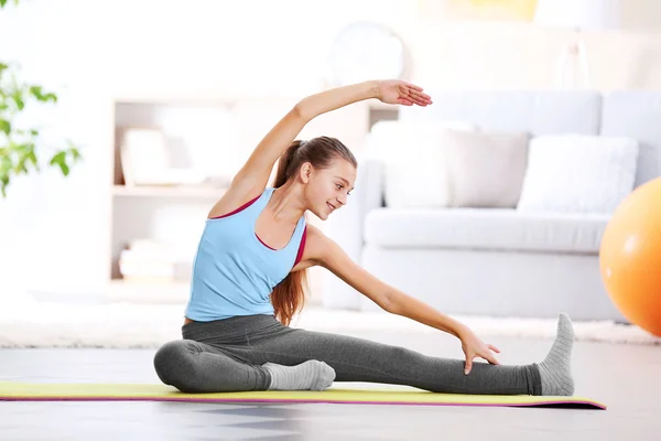 Ung flicka att göra fitness motion inomhus — Stockfoto