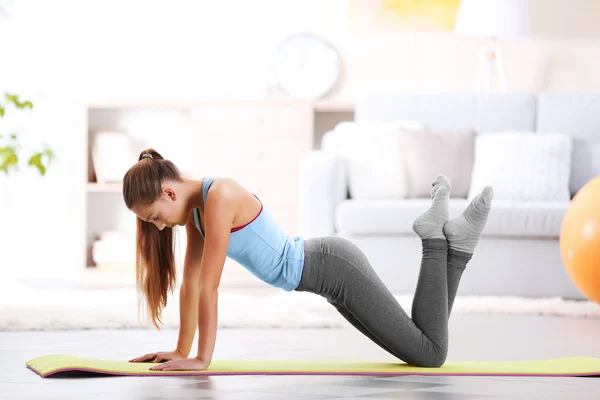 Young girl making fitness exercise indoors — Stock Photo, Image