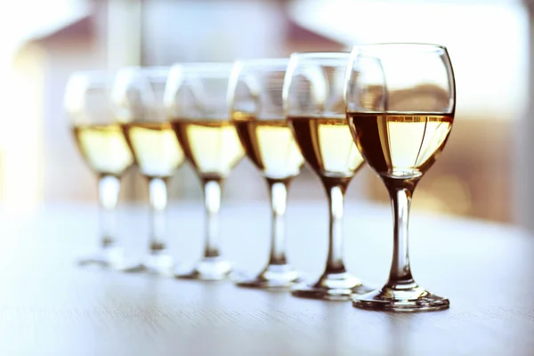 Fila de gafas de vino sobre fondo claro borroso — Foto de Stock