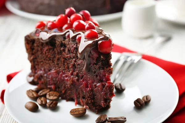 Piece of chocolate cake with cranberries on plate, closeup — Stock Photo, Image