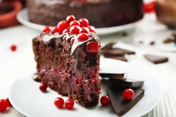 Kawałek ciasto czekoladowe z żurawiny na talerzu, zbliżenie — Zdjęcie stockowe