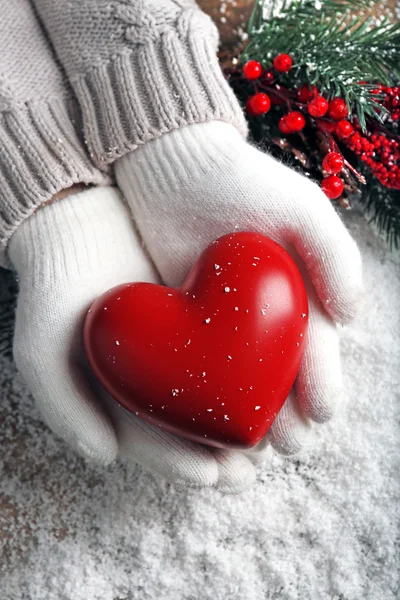 Hands in mittens with decorative heart — Stock Photo, Image