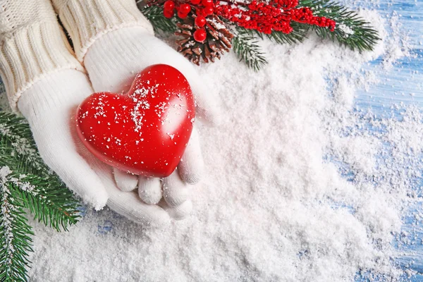 Hands in mittens with decorative heart — Stock Photo, Image