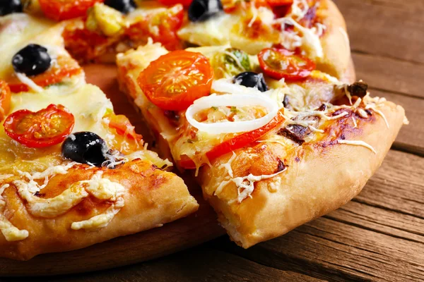 Ahşap masa portre üzerinde taze pizza dilimlenmiş — Stok fotoğraf