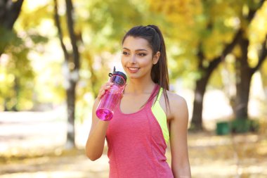 Genç ve güzel kadın su içiyor. 