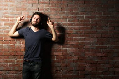 Kulaklıkla müzik dinleyen genç adam. 