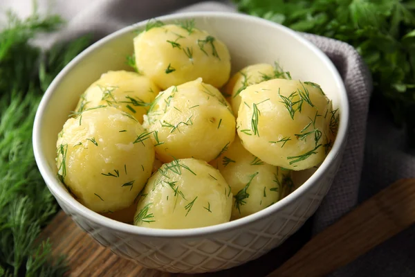 Batatas fervidas com verdes em boliche na mesa de perto — Fotografia de Stock