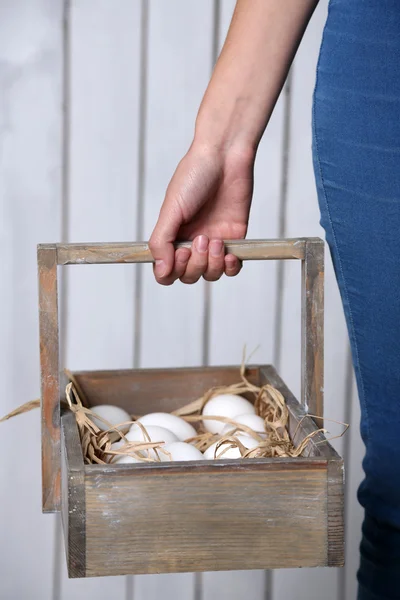 Яйца в корзине в женских руках — стоковое фото