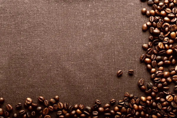 Roasted coffee beans on grey textile background — Stock Photo, Image