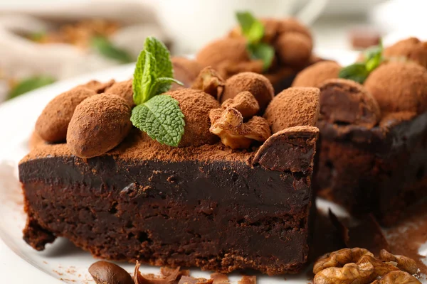 A piece of chocolate cake with walnut and mint on the table, close-up — Stock Photo, Image