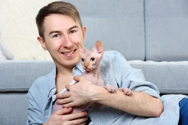 Bonito homem está com gato no chão — Fotografia de Stock